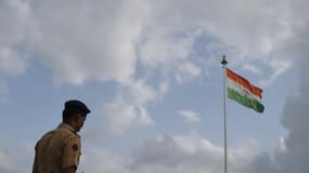 Un policier indien devant le drapeau de l'Inde à Mumbai, le 21 juin 2017.