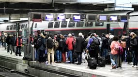 Des voyageurs patientent sur un quai de la gare Montparnasse avant d'embarquer dans un train lors d'une grève des contrôleurs de la SNCF, à Paris le 2 décembre 2022.