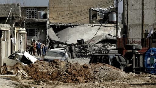 Des habitants au milieu d'un quartier en ruines le 1er mars 2017 à Mossoul Des habitants au milieu d'un quartier en ruines le 1er mars 2017 à Mossoul