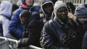 Des migrants patientent devant la plateforme d'accueil des réfugiés de l'ONG Terre d'Asile à Paris, le 26 janvier 2017