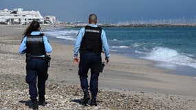 Deux gendarmes en train de marcher sur la plage de Palavas-les-Flots dans l'Hérault.