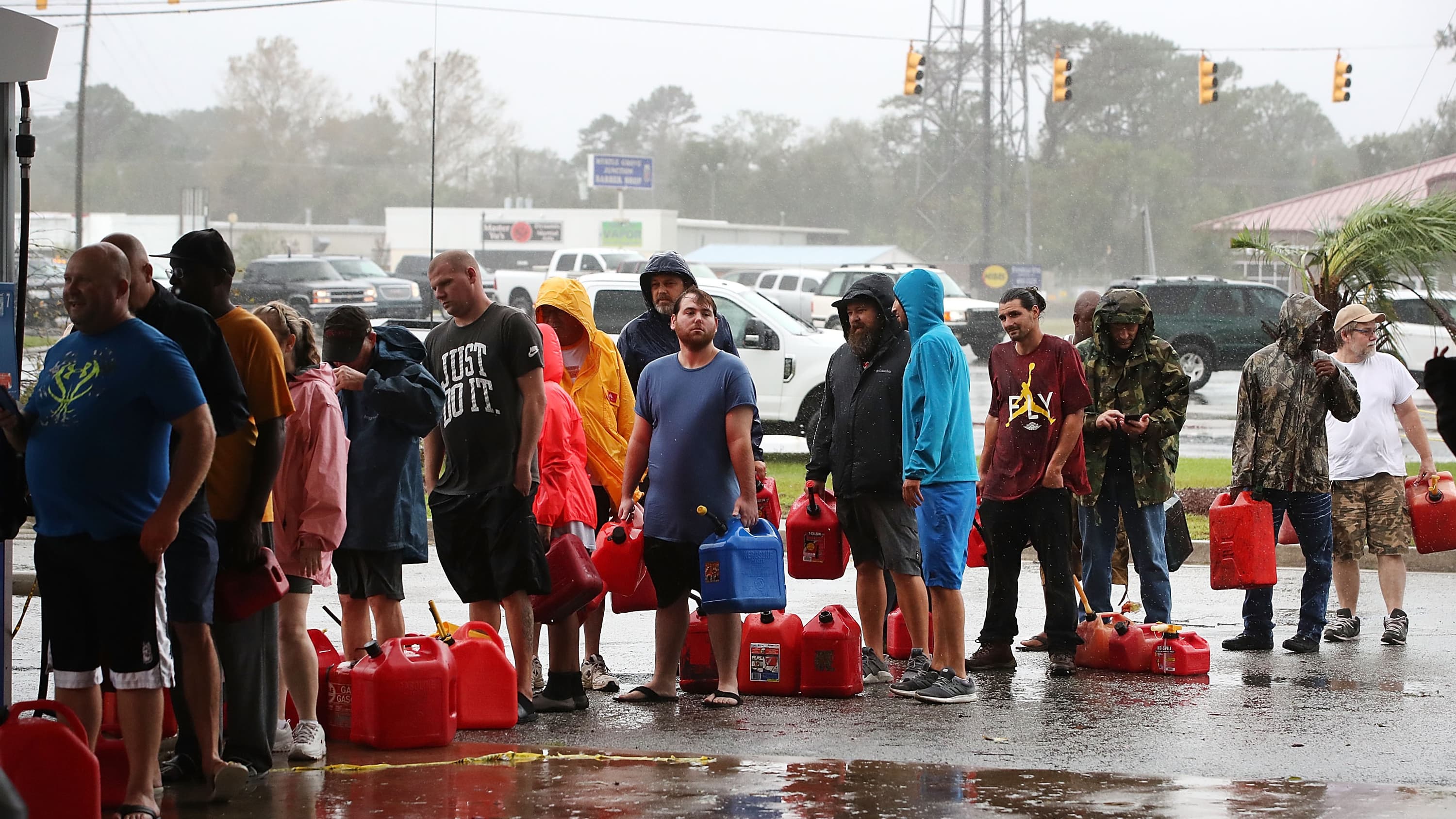 Des habitants de Caroline du Nord font la queue pour acheter de l'essence à une station endommagée, le 15 septembre 2018 à Wilmington. 