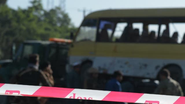Le 20 juin 2016, en Afghanistan, des policiers positionnés devant la scène d'un attentat-suicide contre un bus