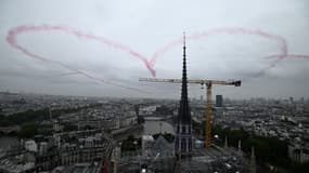 Un cœur réalisé avec de la fumée rouge par 4 avions flotte dans les airs près de la cathédrale Notre-Dame lors de la cérémonie d'ouverture des Jeux olympiques de Paris 2024 à Paris, le 26 juillet 2024.