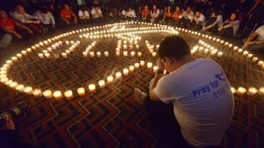 Des proches des passagers du vol MH370 se recueillent à Pékin, le 7 avril 2014.