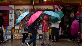 Des touristes marchent avec des parapluies lors de fortes pluies et de vents violents à Ronda, dans le sud de l'Espagne, le 17 mars 2025.