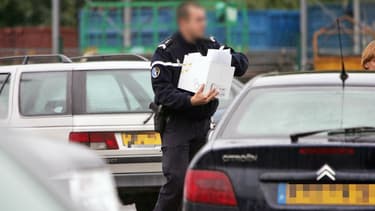 Un gendarme identifie des voitures sur un parking (image d'illustration).