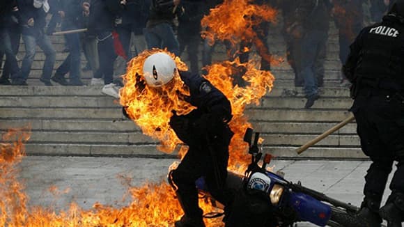 Athènes, 23 février 2011. Policier touché par un cocktail molotov pendant les émeutes devant le Parlement grec.