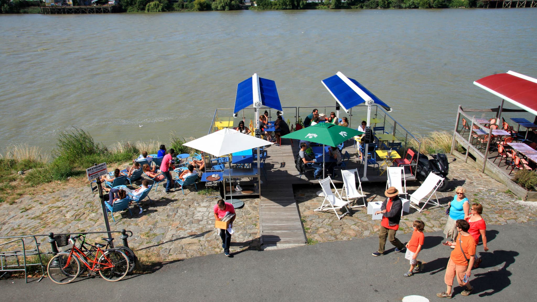Une terrasse où sont attablés des touristes en bord de Loire à Trentemoult. Une terrasse où sont attablés des touristes en bord de Loire à Trentemoult.