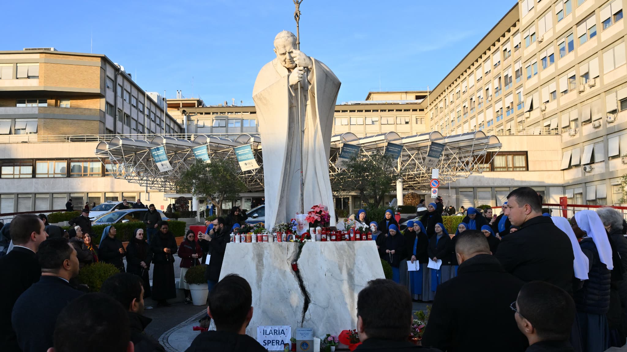Des personnes priant devant la statue de Jean-Paul II, à l'extérieur de l'hôpital Gemelli où le pape François est actuellement hospitalisé depuis le 14 février dernier. Rome, le 22 février 2025. (Photo d'illustration)