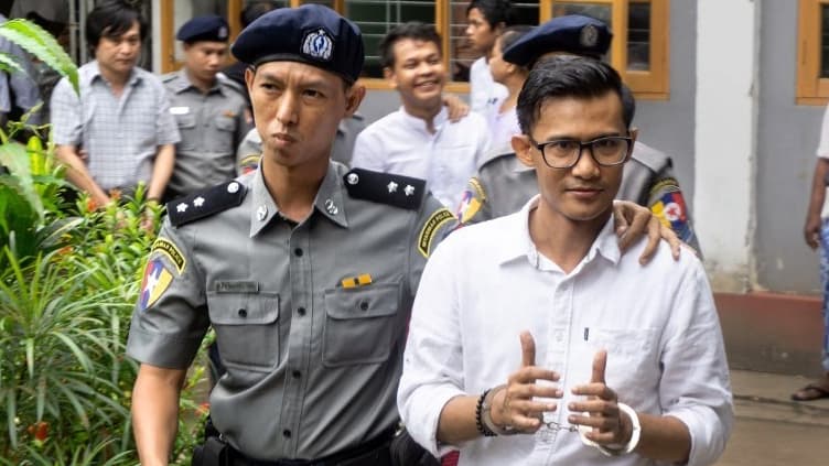 Kyaw Zaw Lin (au premier plan), Phyo Wai Win (le quatrième en partant de la gauche) et Nayi Min (à gauche) quittant le tribunal.