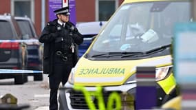 Un officier de police se tenant près de l'endroit où a eu lieu l'explosion mortelle d'une voiture devant un hôpital de Liverpool, le 15 novembre 2021.
