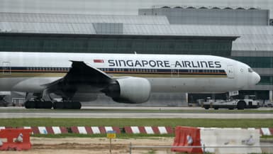 Un Boeing 777-300ER de Singapore Airlines, dont l'aile tribord a été carbonisée par un incendie de moteur lors d'un atterrissage d'urgence, est remorqué sur le tarmac de l'aéroport international de Changi, à Singapour, le 27 juin 2016.