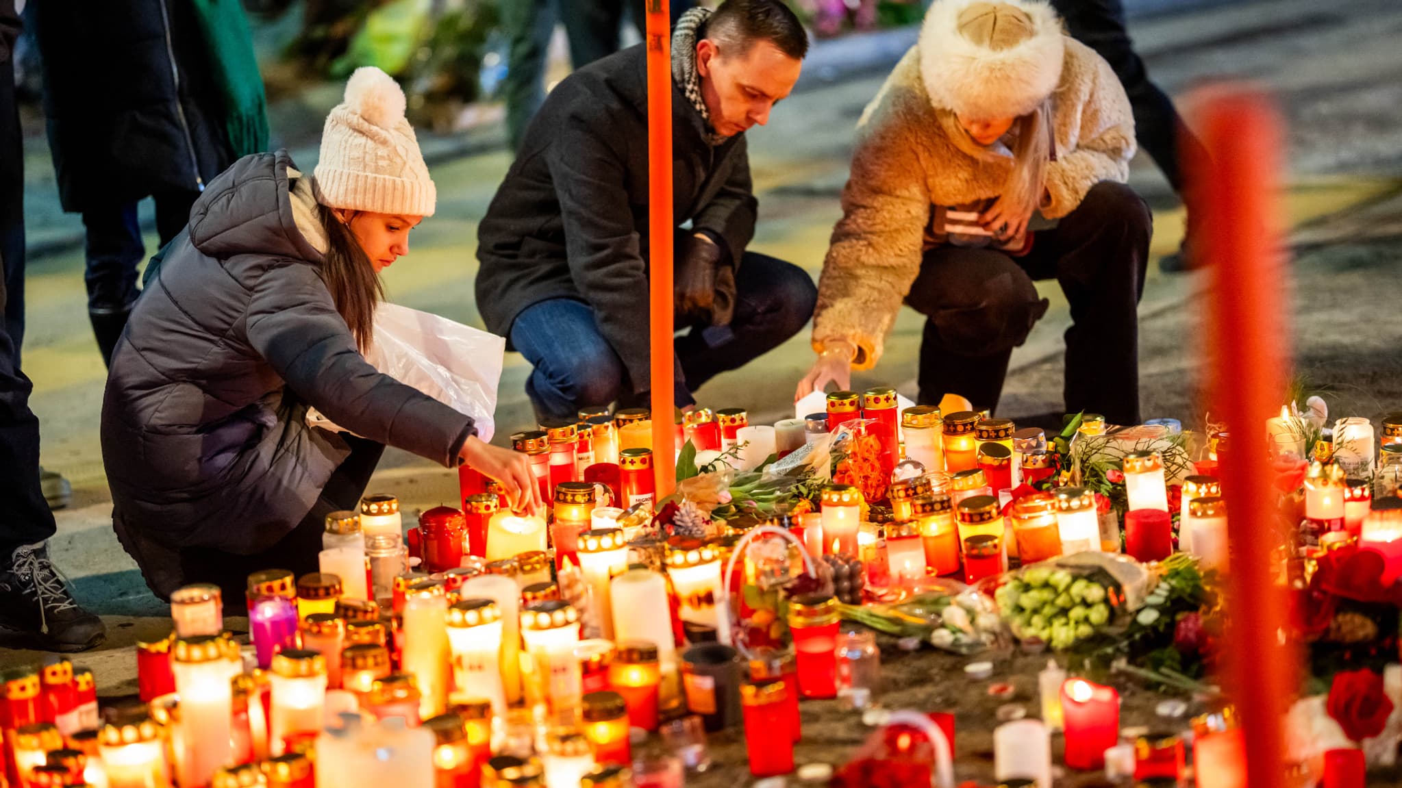 Des personnes en deuil allument des bougies devant un mémorial improvisé près du lieu où un incendie a ravagé un bar pendant les célébrations du Nouvel An dans la station de ski alpine de Crans-Montana, faisant environ 40 morts et plus de 100 blessés, à Crans-Montana, le 2 janvier 2026.
