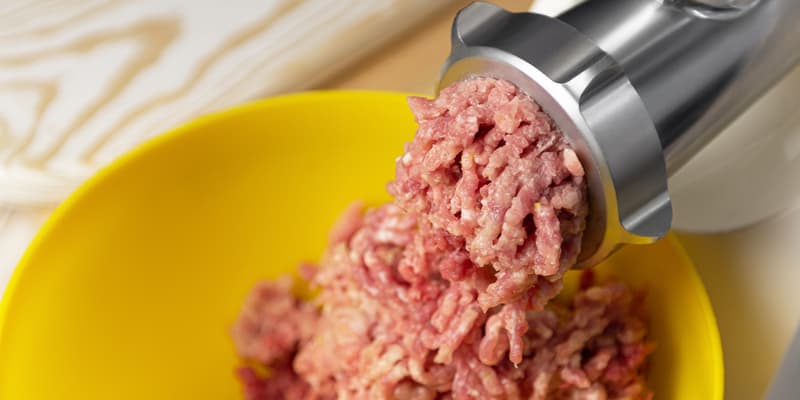 De la viande hachée sortant d'un hachoir (photo d'illustration)