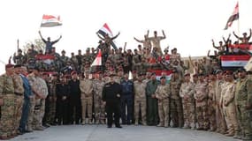 Des soldats irakiens prennent la pose et fêtent leur victoire à Mossoul, aux côtés du Premier ministre Haider al-Abadi, sur une photo diffusée le 10 juillet 2017.