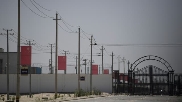 Des drapeaux chinois le long d'une route menant à un centre de rééducation politique où seraient détenus des musulmans ouïghours, le 31 mai 2019 près de Hotan, dans le Xinjiang