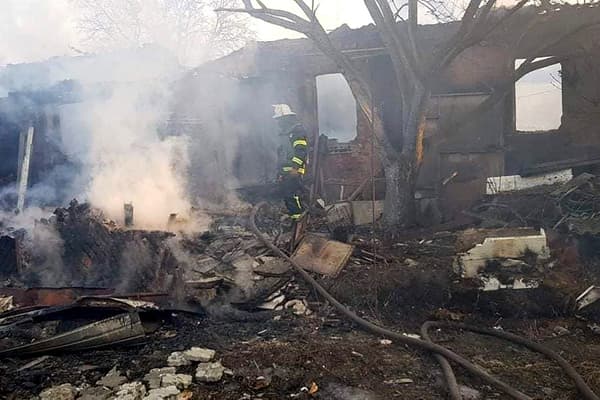 Cette photo prise et publiée par le service d'urgence de l'État ukrainien le 25 mars 2022 montre un pompier en train d'éteindre un incendie après un bombardement russe à Kharkiv.
