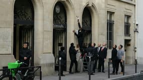 Un agent de sécurité retire une affiche de l'entrée de Sciences Po Paris, après que des étudiants ont pénétré à l'intérieur pour un rassemblement propalestinien, le 7 mai 2024 à Paris