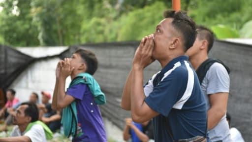 Des hommes encouragent leurs oiseaux pendant un concours de chant à Jakarta, le 7 janvier 2016 Des hommes encouragent leurs oiseaux pendant un concours de chant à Jakarta, le 7 janvier 2016
