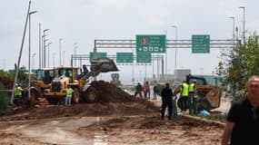 Les services d'urgence israéliens dégagent une route à l'extérieur de l'aéroport israélien Ben Gurion après qu'un missile lancé depuis le Yémen a frappé près de l'installation, le 4 mai 2025. 
