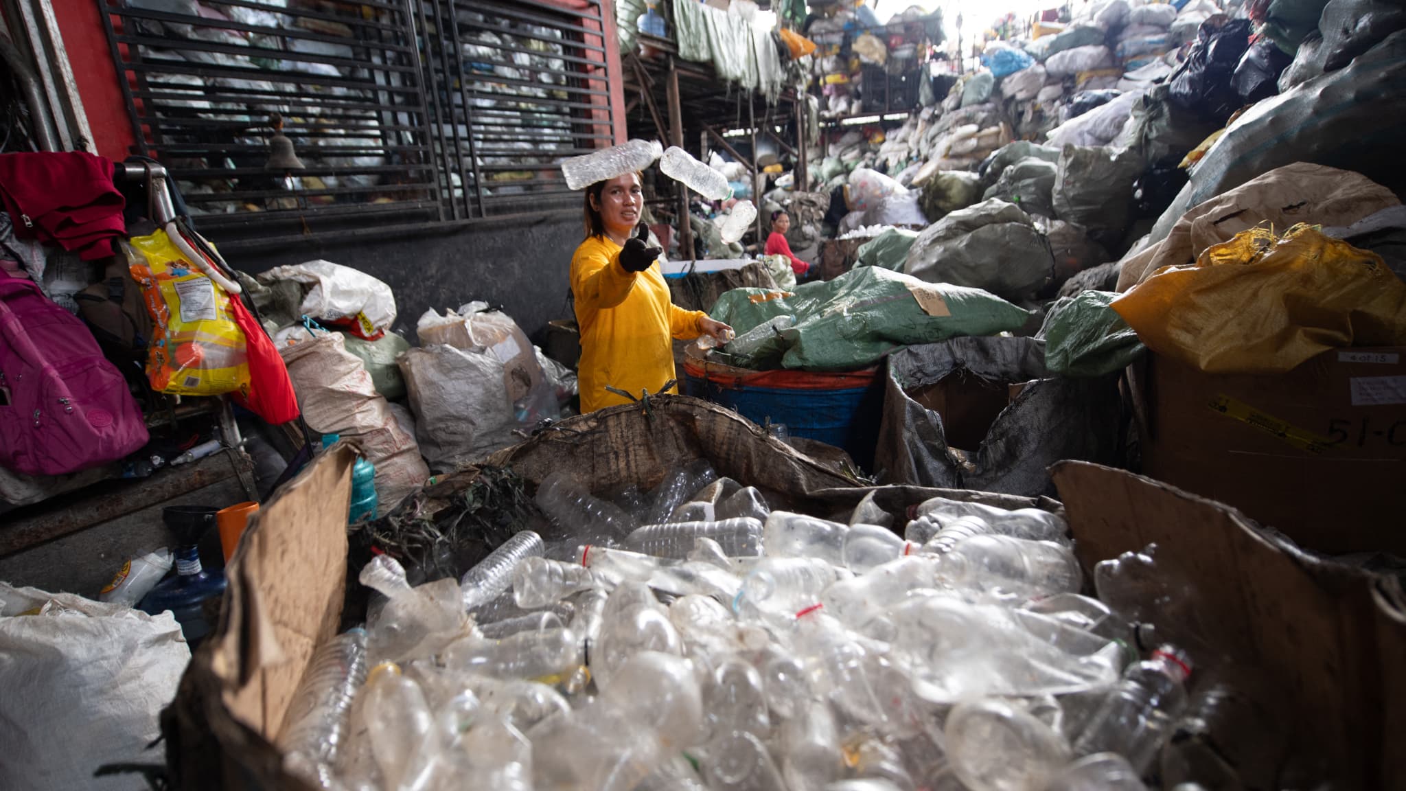 Des ouvriers trient des bouteilles en plastique dans une décharge à Manille, le 7 novembre 2024.