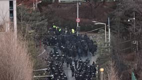 Des policiers entrent dans l'enceinte de la résidence présidentielle du président sud-coréen destitué Yoon Suk Yeol à Séoul, vu depuis une colline, le 15 janvier 2025.