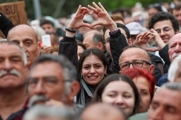 Une jeune femme fait un cœur avec ses mains le 21 avril 2023 à Balikesir, en Turquie, lors d'un rassemblement de Kemal Kiriçdaroglu.