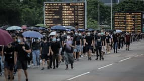 Des manifestants brandissant des parapluies près de l'aéroport. 