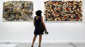"Desert Bike, 1991" (à gauche) et "White Handless, 1987" du plasticien Arman exposés au Centre Pompidou, à Paris. Une rétrospective de l'oeuvre de l'artiste français, connu pour ses violons en lamelles et autres carcasses de fauteuils calcinés, est présen
