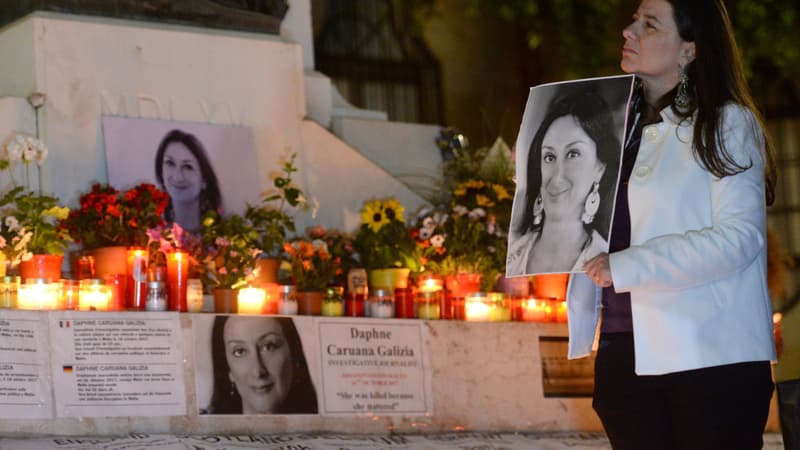 Une femme porte le portrait de Daphne Caruana Galizia. 