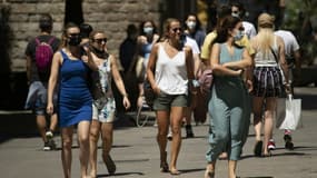 Des passants masqués et non masques dans une rue de Barcelone, le 26 juin 2021 en Espagne