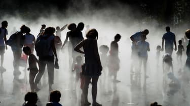 Enfants et parents se rafraichissent près d'une fontaine à Nantes le 26 août 2016.