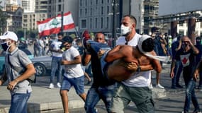 La star du basketball au Liban Fadi al-Khatib transporte en courtant un manifestant blessé lors des manifestations à Beyrouth contre le pouvoir, le 8 août 2020 