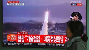 Une femme passe devant un écran de télévision montrant un nouveau tir de missile en Corée du nord, le 5 avril 2017 à Séoul
