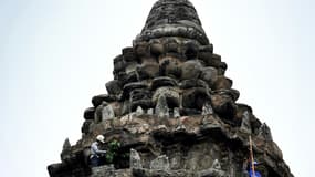 Un jardinier enlève des pousses d'arbre sur le temple d'Angkor Wat, le 12 octobre 2020