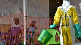 Un soigneur marche vers des patients en quarantaine dans un centre de traitement d'Ebola à Conakry, en Guinée, le 21 août 2015