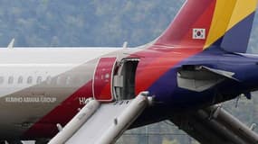 Un Airbus A320 de la compagnie sud-coréenne Asiana Airlines avec sa passerelle d'évacuation déployée après son atterrissage mouvementé sur le tarmac de l'aéroport d'Hiroshima à Mihara, dans l'ouest du Japon le 15 avril 2015