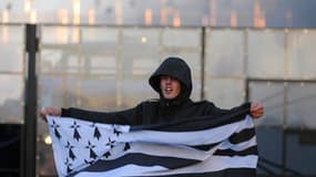 Un manifestant brandit un drapeau breton prêt du portique de l'Ecotaxe de Jugon-les-Lacs dans les Côtes-d'Armor le 9 novembre 2013.