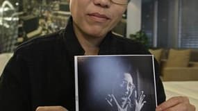 Liu Xia, l'épouse de Liu Xiaobo, dissident chinois distingué cette semaine par le prix Nobel de la paix, présentant un portrait de son mari. Liu Xia est assignée à résidence dans son appartement de Pékin, selon l'association américaine de défense des droi