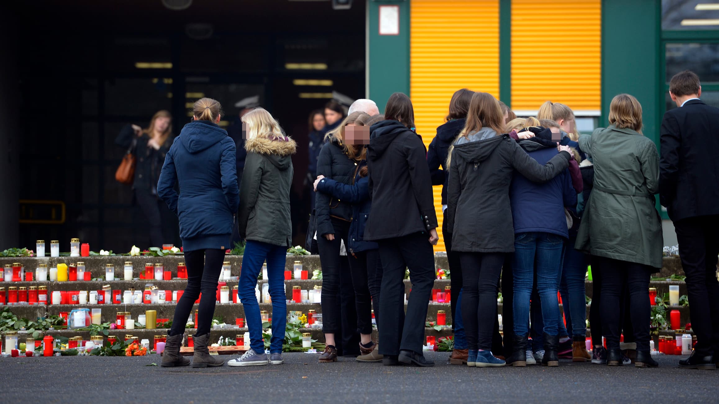 Sous le choc, des élèves se soutiennent, face aux bougies allumées sur les marches de leur lycée. Sous le choc, des élèves se soutiennent, face aux bougies allumées sur les marches de leur lycée.