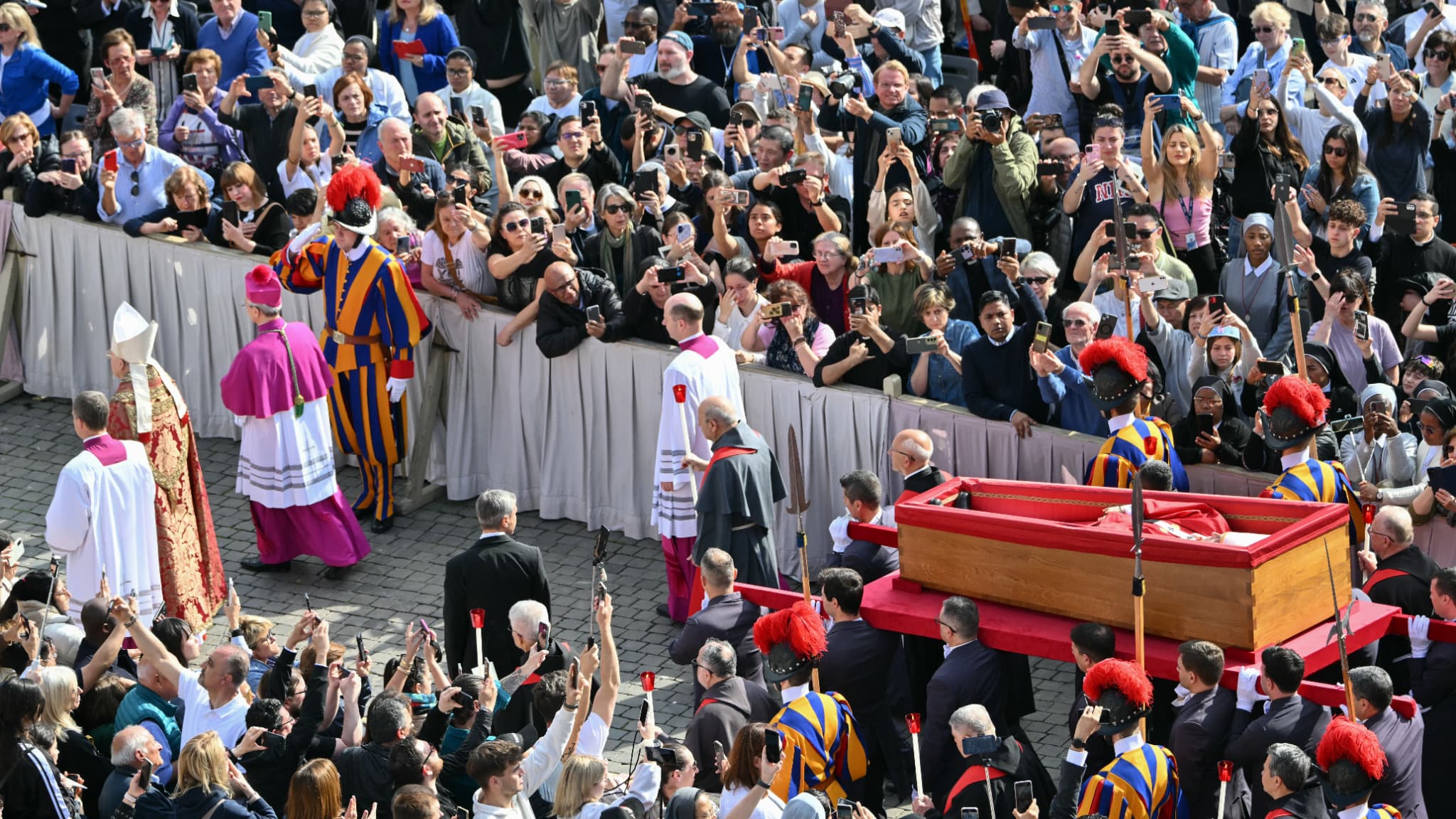 Les porteurs de cercueils, à côté des gardes suisses, portent le cercueil du pape François lors de son transport de la chapelle de Santa Marta à la basilique Saint-Pierre le 23 avril 2025.