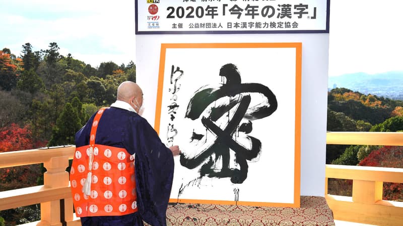Seihan Mori, maître de l'ancien temple Kiyomizu, utilise la calligraphie pour écrire le caractère chinois «mitsu», qui a été sélectionné comme le meilleur kanji pour symboliser l'année de 2020 au temple de Kyoto, dans l'ouest du Japon, le 14 décembre 2020.