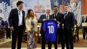 Rai Souza, la première dame du Brésil Rosangela "Janja" da Silva, le président brésilien Lula, Dimitri Payet et le président français Emmanuel Macron posent avec le maillot de Kylian Mbappé au Palace Itamaraty (Brasilia), le 28 mars 2024