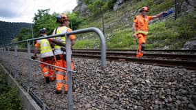 Des employés de la SNCF contrôlent la sécurité d'une voie ferrée à Deluz, le 2 juillet 2024 dans le Doubs