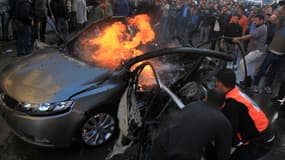 Des Palestiniens éteignent la voiture de Ahmaed Jaabar