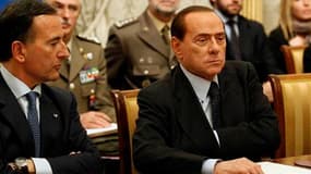 Franco Frattini (à gauche), lors d'une réunion d'urgence sur la situation en Libye autour de Silvio Berlusconi, mardi. Le ministre italien des Affaires étrangères estime que les estimations faisant état d'un millier de morts en Libye sont "crédibles" et c
