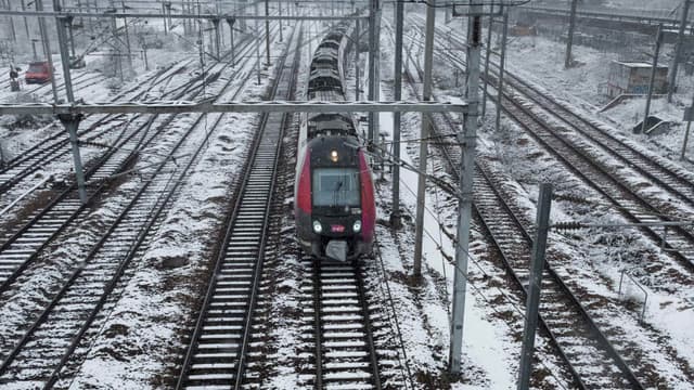 Un train de la SNCF arrive Gare de l'est à Paris sous la neige