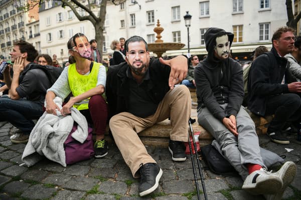 Des manifestants arborent des masques à l'effigie d'Alexandre Benalla, le 1er mai 2019 à Paris.