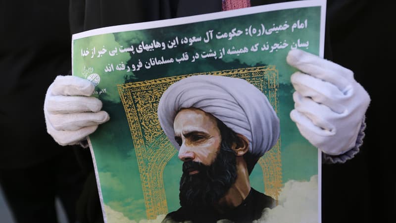 Une Iranienne brandit le portrait du dignitaire chiite exécuté en Arabie saoudite lors d’une manifestation à Téhéran